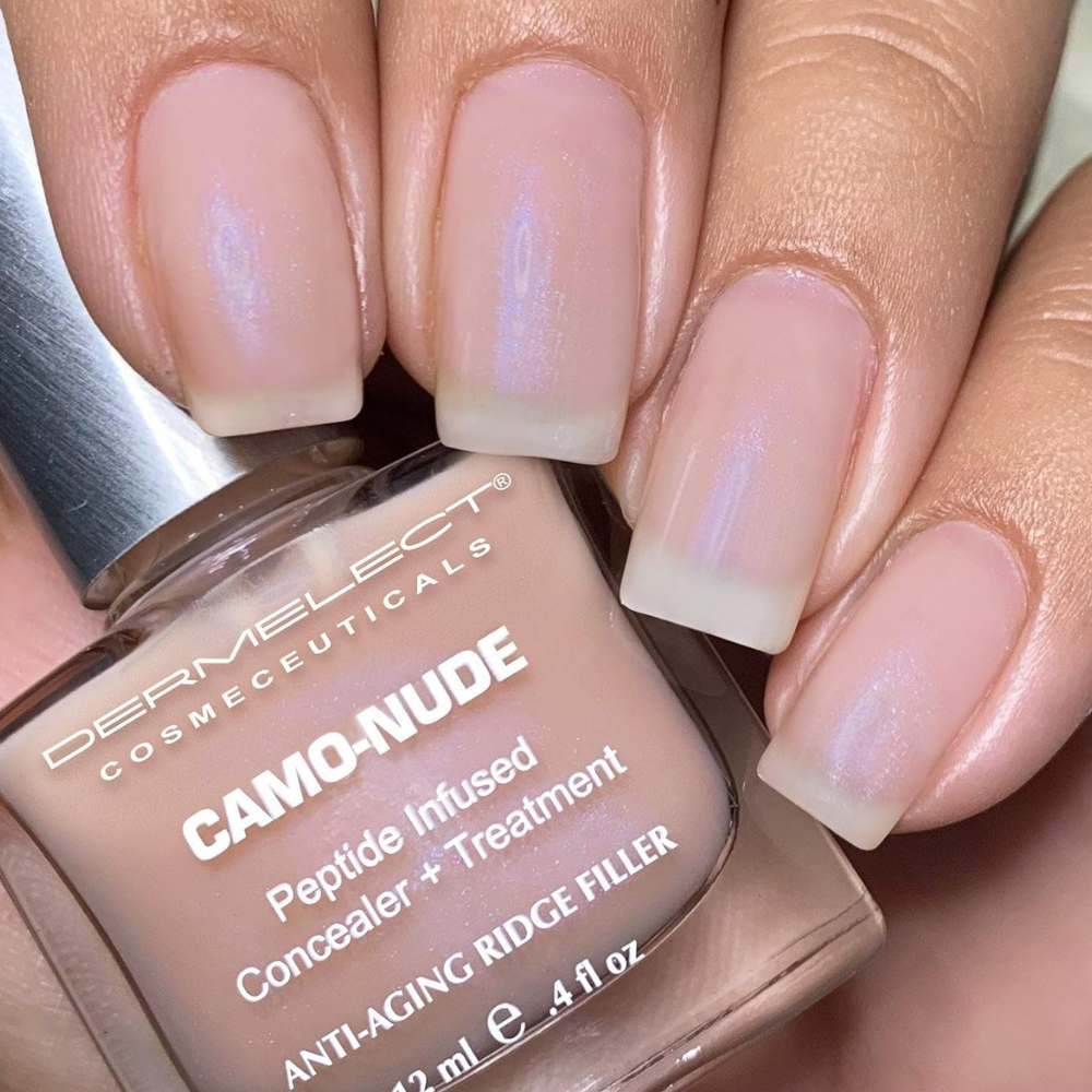 Dermelect Camo-Nude Concealer + Treatment (3) Zbliżenie na paznokcie pokryte Dermelect Camo-Nude Concealer + Treatment. Delikatny różowo-beżowy odcień z subtelnym opalizującym połyskiem optycznie wygładza płytkę i nadaje jej zadbany wygląd.