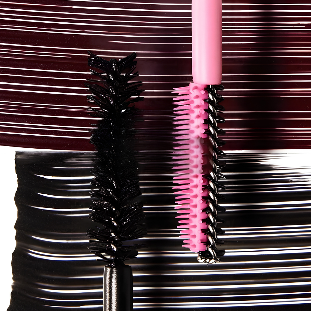 Dibs Double Standard Burgundy Primer & Mascara Duo Dibs Double Standard Burgundy Primer & Mascara Duo - zbliżenie na dwie szczoteczki do rzęs: czarną szczoteczkę tuszu oraz różową szczoteczkę primera. Grafika na bordowo-czarnym tle podkreśla trwałość makijażu, odporność na rozmazywanie i osypywanie przez cały dzień.