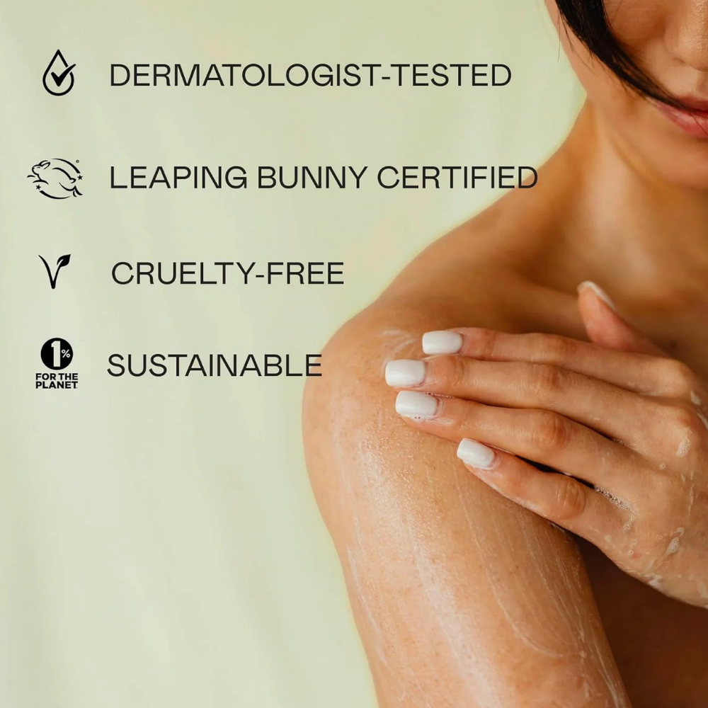 Doc & Glo Daily Mantra Boosting Body Wash (5) Kobieta masuje ramię pokryte delikatną pianą żelu do mycia ciała Doc & Glo Daily Mantra Boosting Body Wash. Grafika na jasnozielonym tle podkreśla dermatologicznie testowaną formułę, certyfikat Leaping Bunny, brak testów na zwierzętach oraz zaangażowanie marki w zrównoważony rozwój.