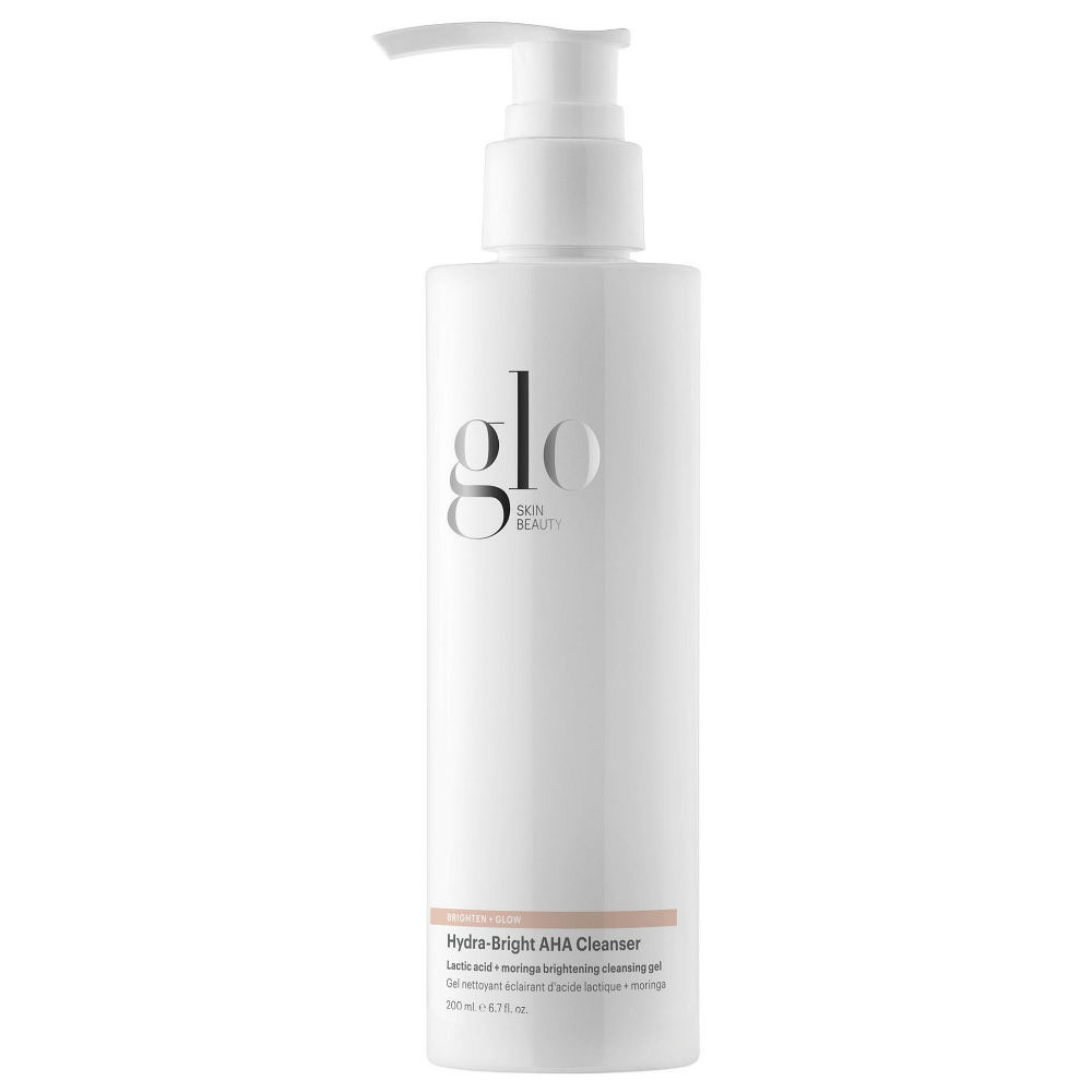 Glo Skin Beauty Hydra Bright AHA Cleanser Glo Skin Beauty Hydra-Bright AHA Cleanser 200 ml - rozświetlający żel do mycia twarzy z kwasem mlekowym AHA i moringą. Delikatnie oczyszcza, złuszcza martwy naskórek, wygładza cerę i pomaga przywrócić jej naturalny blask. Biała butelka z pompką.