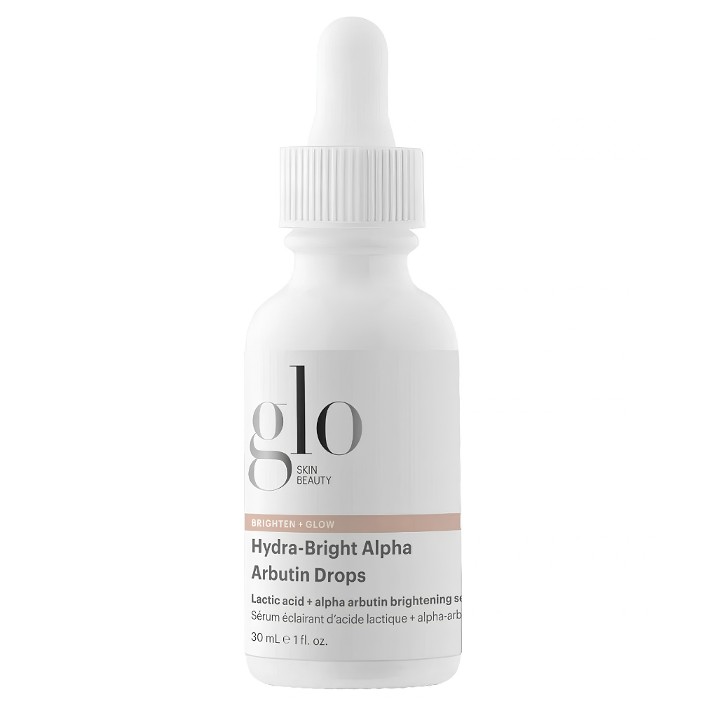 Glo Skin Beauty Hydra Bright Alpha Arbutin Drops Glo Skin Beauty Hydra-Bright Alpha Arbutin Drops - serum rozświetlające z arbutyną i kwasem mlekowym AHA, 30 ml. Biała szklana buteleczka z pipetą, minimalistyczną etykietą i logo marki Glo Skin Beauty, przedstawiona na czystym białym tle.