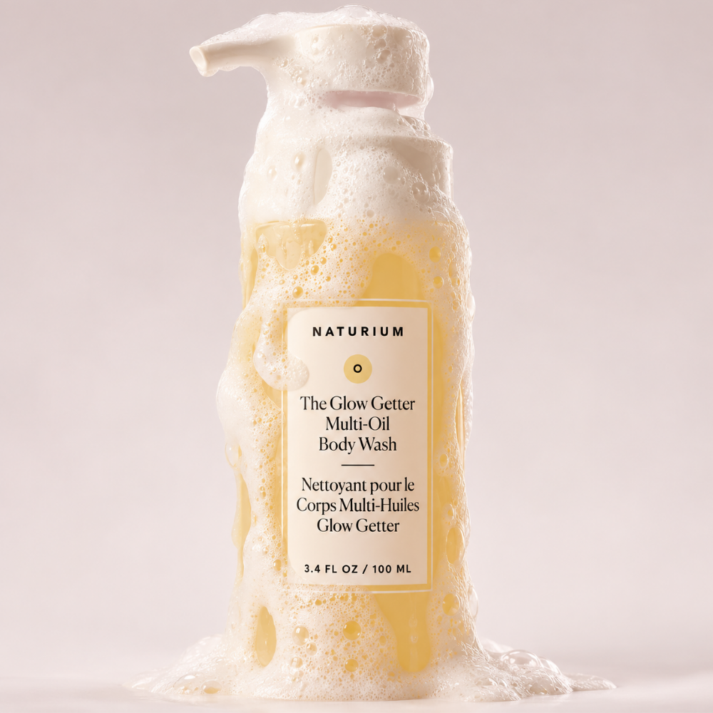 Naturium The Glow Getter Multi Oil Hydrating Body Wash Naturium The Glow Getter Multi-Oil Body Wash - olejkowy żel do mycia ciała w butelce z pompką, pokryty delikatną pianą, na jasnym, neutralnym tle.