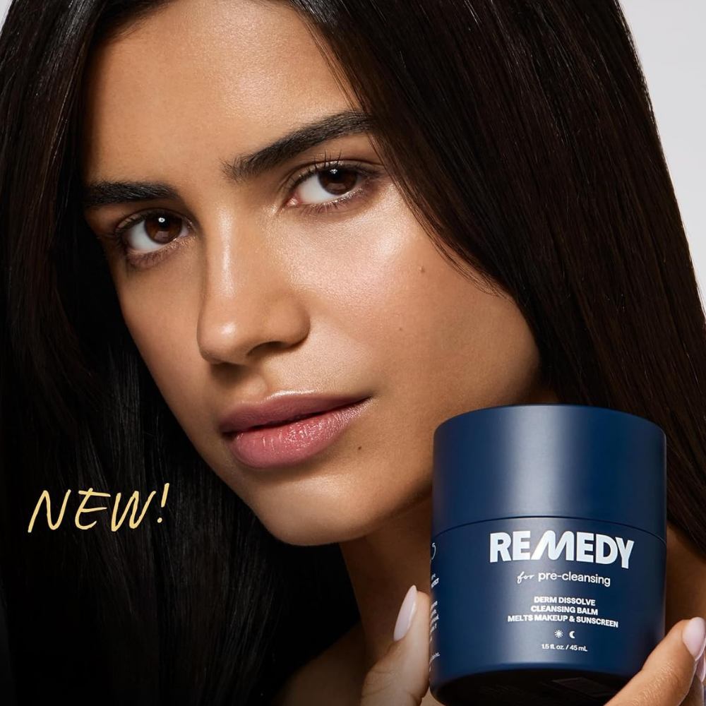 REMEDY for Pre-Cleansing (2) REMEDY for Pre-Cleansing Derm Dissolve Cleansing Balm - balsam do demakijażu i usuwania SPF, prezentowany przez modelkę o promiennej cerze. Granatowy słoiczek o pojemności 45 ml na tle zbliżenia twarzy kobiety.