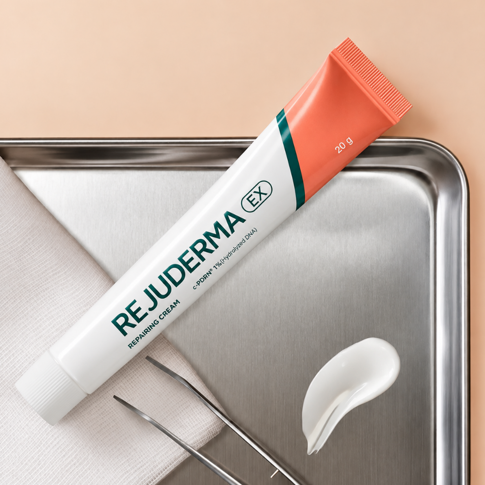 Rejuderma Ex Repairing Cream c PDRN 1% (5) tekst alternatywny REJUDERMA EX Repairing Cream c-PDRN 1% - koreański krem kojąco-odbudowujący do twarzy 20 g w biało-koralowej tubce z zielonym logo, prezentowany na metalowej tacy obok białej gazy, pęsety kosmetycznej i próbki kremowej konsystencji.