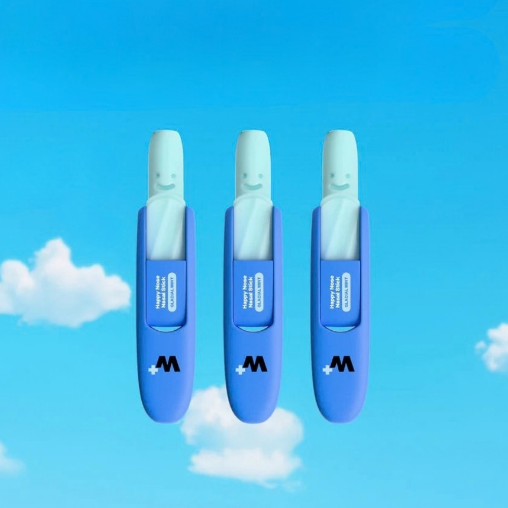 Wizard HAPPY NOSE NASAL STICK in GLACIAL MINT (2) Wizard Wellness Happy Nose Glacial Mint - trzy niebieskie sztyfty inhalacyjne do nosa z miętowym wkładem, przedstawione na tle błękitnego nieba i białych chmur.
