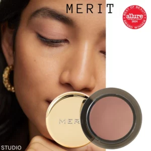 Zdjęcie przedstawia cienie do powiek w kremie marki Merit, w odcieniach od klasycznego beżu po różowe i czerwone tonacje, z napisem "MERIT" i nagrodą Allure Best of Beauty 2024 na opakowaniu.