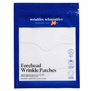 "Niebieska saszetka Wrinkles Schminkles Eye Wrinkle Patches z sześcioma przezroczystymi silikonowymi płatkami pod oczy widocznymi pod białym okienkiem. Na dole umieszczony jest napis Eye Wrinkle Patches oraz ikony informujące o produkcji w USA, liczbie płatków i liczbie użyć."