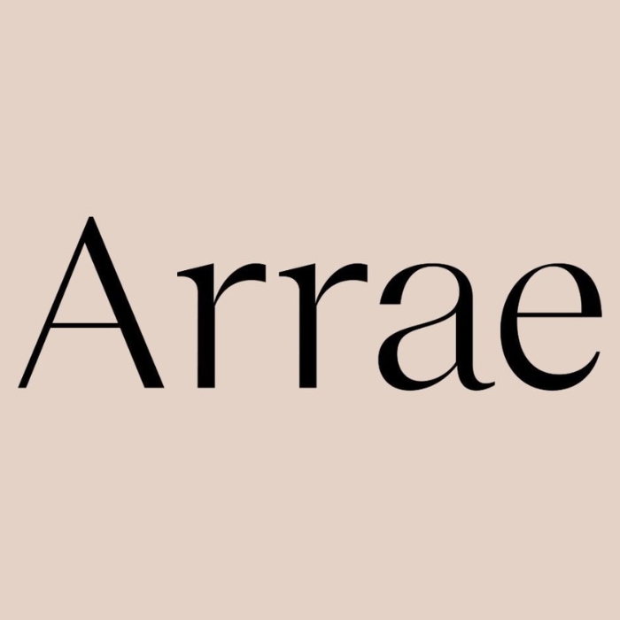 Na zdjęciu widać logo marki Arrae na jasnym, beżowym tle. Nazwa marki jest zapisana czarną, elegancką czcionką, która nadaje minimalistyczny i nowoczesny charakter. Logo symbolizuje prostotę oraz luksusowy styl produktów Arrae, znanych z wysokiej jakości suplementów i akcesoriów podróżnych.