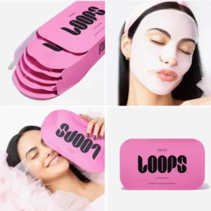 Różowe opakowanie masek Loops z kilkoma maskami w środku. Kobieta w białej masce na twarzy z zamkniętymi oczami, emanująca spokojem. Inna modelka przytula opakowanie, co nadaje produktowi wrażenie komfortu i luksusu. Maski mają na celu rozświetlenie skóry.
