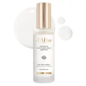 Obraz przedstawia produkt d'Alba Intensive Volufiline Spray Ampoule. Jest to elegancka, przezroczysta butelka ze złotą nakrętką i minimalistycznym, luksusowym designem. Na butelce znajduje się nazwa produktu oraz informacja, że zawiera ekstrakt z białej trufli, która poprawiają nawilżenie oraz elastyczność skóry. Obok butelki widoczne są kropelki produktu, które ukazują jego lekką, mleczną konsystencję. Całość emanuje poczuciem wysokiej jakości.Produkt przeznaczony jest do pielęgnacji skóry w celu uzyskania promiennej i elastycznej cery.