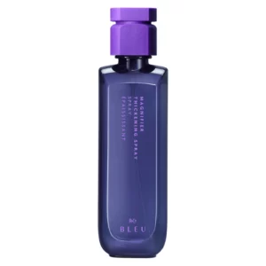 Elegancka butelka R+Co Bleu Magnifier Thickening Spray w głębokim, fioletowym odcieniu, podkreślona matową nakrętką w tym samym kolorze. Produkt stworzony, aby nadać włosom większą objętość i gęstość.