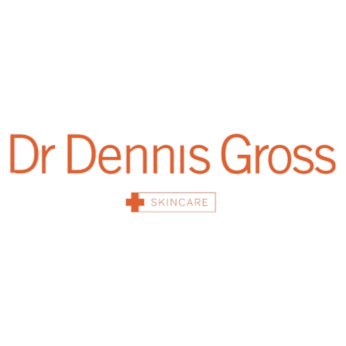 Logo marki Dr Dennis Gross Skincare. Nazwa „Dr Dennis Gross” jest napisana pomarańczową czcionką, a pod nią widnieje słowo „Skincare” w prostokątnym obramowaniu z symbolem krzyża po lewej stronie.