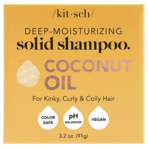 Hair 7 Na zdjęciu znajduje się opakowanie szamponu w kostce marki Kitsch z wyraźnym napisem „Deep-Moisturizing Solid Shampoo – Coconut Oil” oraz ikonami wskazującymi na wegańskie i przyjazne kolorom właściwości produktu.