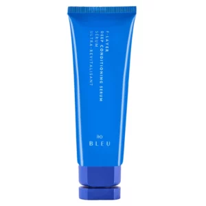 Na zdjęciu znajduje się niebieska tubka produktu R+Co BLEU F-Layer Deep Conditioning Serum z eleganckim minimalistycznym designem.