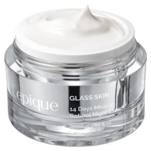 Na zdjęciu widoczny jest elegancki słoiczek kremu Lepique Glass Skin 14 Days Miracle Retinol Night Cream o pojemności 50 ml. Opakowanie wykonane jest z przezroczystego materiału o luksusowym designie, z minimalistycznym białym nadrukiem. Wewnątrz znajduje się krem o gładkiej, jedwabistej konsystencji w białym kolorze, sugerujący intensywne działanie pielęgnacyjne. Produkt obiecuje efekty "szklanej skóry" dzięki zastosowaniu retinolu i innych składników aktywnych, idealny do wieczornej pielęgnacji skóry twarzy.