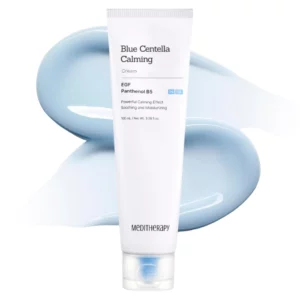 Na zdjęciu znajduje się tubka kremu Blue Centella Calming Cream ustawiona na białym tle z rozmazanym kosmetykiem w jasnoniebieskim odcieniu w tle.