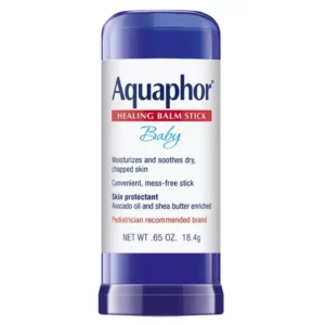 Zdjęcie przedstawia Aquaphor Baby Healing Balm Stick – ochronny balsam do skóry dzieci w sztyfcie. Opakowanie ma niebieską zakrętkę i białą etykietę z nazwą marki Aquaphor oraz oznaczeniem produktu Healing Balm Stick Baby. Na etykiecie znajdują się informacje o właściwościach balsamu – nawilża i koi suchą, spierzchniętą skórę, zapewnia wygodną, czystą aplikację oraz zawiera olej z awokado i masło shea. Produkt jest opisany jako ochrona skóry i marka rekomendowana przez pediatrów. W dolnej części etykiety widnieje informacja o pojemności: (18,4 g).