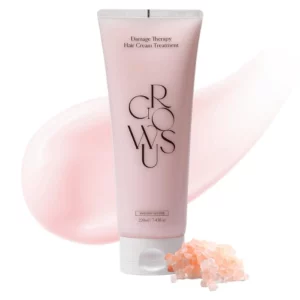 Tubka kremu regenerującego i nawilżającego do włosów Damage Therapy Hair Cream marki Growus. Obok tubki leżą różowe kamyki, co sugeruje odżywiające działanie produktu, a w tle znajduje się plama kremu.