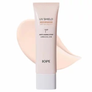 Krem IOPE UV Shield Tone Up Sun nałożony obok tubki, pokazujący beżowo-różowy odcień i konsystencję produktu