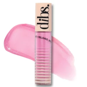 Błyszczyk Dibs Go To Glossy Balm w odcieniu Rock Candy, o jasnoróżowej, opalizującej barwie, na tle rozświetlonego różowego pociągnięcia.