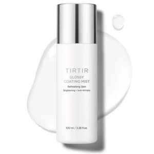 Biała butelka TIRTIR Glossy Coating Mist sfotografowana z bliska na tle rozlanej kropli płynu, z widocznym opisem funkcji produktu: „Brightening, Anti-Wrinkle, Refreshing Skin”.