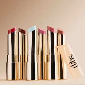 Zestaw luksusowych szminek DIBS Jam Jam Lip Plumping Lipstick Melt w eleganckich, złotych opakowaniach — każda w innym odcieniu: od głębokiej czerwieni i brązu po delikatny róż i nude, z przezroczystą zatyczką z logo marki DIBS.