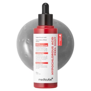 Butelka serum Medicube Hypochlorous Acid Peel Shot w czerwono-białym opakowaniu z pipetą, ustawiona na tle szarej, połyskującej powierzchni. Produkt widoczny z przodu z czytelnym napisem „Gentle Exfoliating Care”, podkreślającym jego działanie złuszczające i oczyszczające.