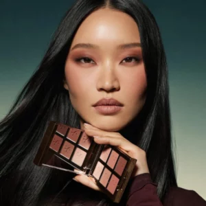 makeup 15 Modelka z makijażem oczu w różano-mauve tonacji trzyma otwartą paletę Patrick Ta Artistry Edit Eyeshadow Palette.