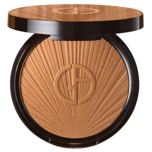 Otwarty kompakt bronzera Armani Luminous Silk ukazujący promieniste tłoczenie i logo na środku, sfotografowany na czystym białym tle.