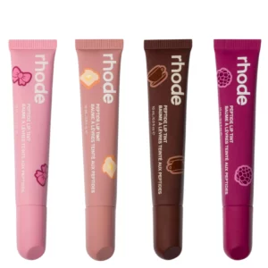 Zdjęcie przedstawia cztery błyszczyki do ust Rhode Peptide Lip Tint w limitowanej edycji zapachowej. Od lewej: odcień Ribbon w różowym opakowaniu, Toast w ciepłym beżu, Espresso w czekoladowym brązie oraz Raspberry Jelly w intensywnym malinowym kolorze. Każda tubka ma minimalistyczny design z białym logo „rhode” i grafiką symbolizującą zapach.