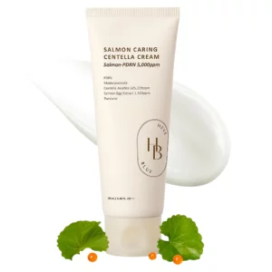 Tuba kremu Heveblue Salmon Caring Centella Cream przedstawiona na białym tle z porcją kremu, liśćmi wąkroty azjatyckiej i pomarańczowymi kulkami ekstraktu z ikry łososia.