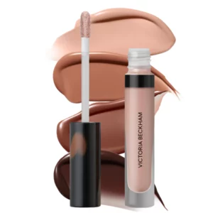 Victoria Beckham Posh Gloss – błyszczyk do ust w neutralnym beżowo-nude odcieniu; przezroczyste opakowanie z czarną nakrętką, aplikator typu doe-foot, w tle widoczne smugi błyszczyka w kilku odcieniach nude i brązu na białym tle.