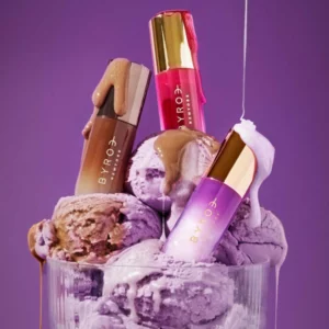 Zestaw olejków do ust Byroe Sweet Treats Lip Oil Trio zanurzonych w deserowej stylizacji lodowej, prezentacja luksusowych olejków do ust z efektem glow i pielęgnacją.