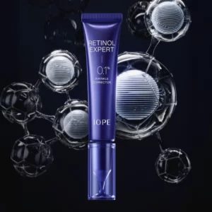 IOPE Retinol Expert 0,1% Wrinkle Corrector w granatowej tubce na ciemnym tle z wizualizacją cząsteczek technologii retinolowej wokół opakowania.