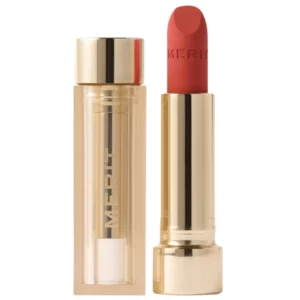 Opakowanie Merit Signature Lip Lightweight Lip Blush – złota pomadka z wysuniętym sztyftem, pokazująca luksusowy design produktu.