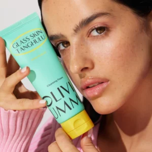 Oliviaumma Glass Skin Tanghulu Cleansing Foam – pianka do oczyszczania twarzy, modelka trzyma produkt przy twarzy, efekt glow i czysta skóra.