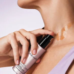 Na zdjęciu widoczny jest sposób aplikacji serum na skórę szyi z użyciem pompki. Lekka formuła rozprowadza się równomiernie i nadaje skórze delikatny połysk.