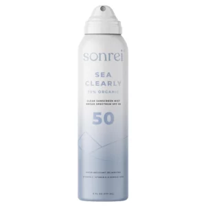 Biało-niebieska butelka sprayu Sonrei Sea Clearly SPF 50 – przezroczysta mgiełka przeciwsłoneczna o szerokim spektrum działania i 70% składników organicznych.