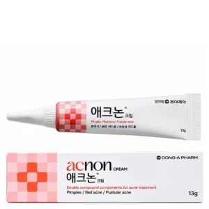 Packshot koreańskiego kremu na niedoskonałości Acnon – biała tubka z różowo-czerwonym wzorem oraz dopasowane opakowanie kartonowe na jasnym tle, prezentujące minimalistyczny design produktu.