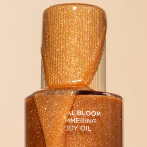Zbliżenie na rozświetlający olejek do ciała Saltair Santal Bloom Shimmering Body Oil z drobinkami złotego glow.