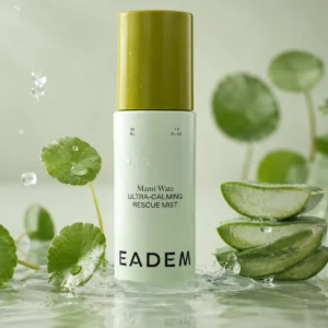 Packshot Eadem Mami Wata Ultra-Calming Rescue Mist otoczony aloesem i zielonymi roślinami, podkreślający kojący i nawilżający charakter produktu.