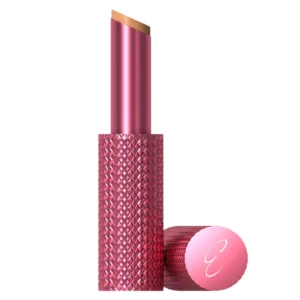 makeup 22 . Packshot Erica Taylor x Doll 10 Let’s Glow Correcting Balm z charakterystycznym różowym opakowaniem i skośnym aplikatorem na jasnym tle.