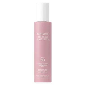 Minimalistyczne zdjęcie produktu Tan-Luxe Sci-Tech Sunscreen SPF 50 w różowym opakowaniu na jasnym tle. Lekka mgiełka ochronna do ciała z szerokopasmową ochroną UVA i UVB.