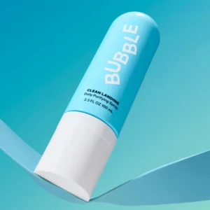 Bubble Clean Landing Daily Purifying Spray w jasnoniebieskim opakowaniu, ułożony ukośnie na turkusowym tle.
