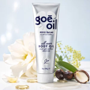 Jao Brand Goē Oil – wielofunkcyjny półstały olejek do ciała, włosów i twarzy na tle białych kwiatów, liści oraz naturalnych olejów roślinnych, podkreślających bogatą formułę z 28 olejami i masłami.