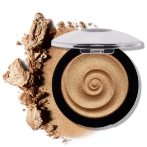 Otwarty rozświetlacz Laura Geller Baked Gelato Swirl Illuminator Gilded Honey w złocistym odcieniu, otoczony rozsypanym pudrem na białym tle.