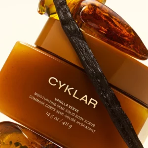 CYKLAR Vanilla Verve Moisturizing Semi-Solid Body Scrub: otwarty słoik nawilżającego peelingu do ciała z masłem shea, wypełniony białą formułą z drobnymi cząsteczkami złuszczającymi.