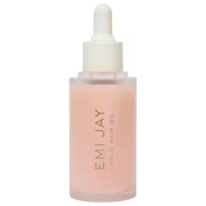 Na zdjęciu znajduje się Emi Jay Halo Hair Oil w różowej, matowej butelce z białą pipetą na białym tle.
