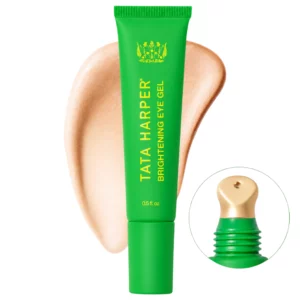 Na zdjęciu znajduje się Tata Harper Brightening Eye Gel w zielonej tubce z metalowym, chłodzącym aplikatorem oraz swatchem świetlistej żelowej formuły.