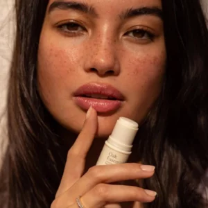 Kobieta aplikująca na usta balsam Oak Essentials Conditioning Lip Balm - nawilżający balsam do ust nadający miękkość, wygładzenie i naturalny połysk.